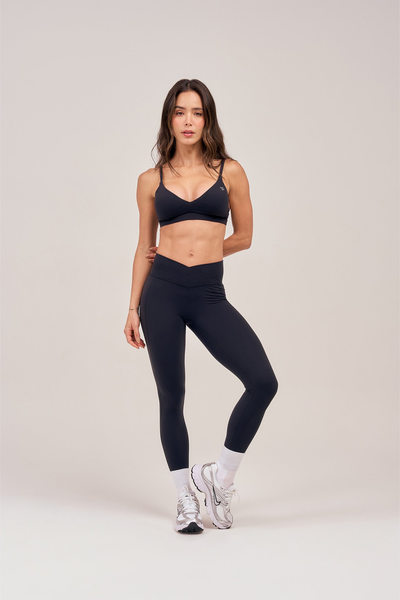 Woman in the black Core Bare Top and matching leggings, full-body front view